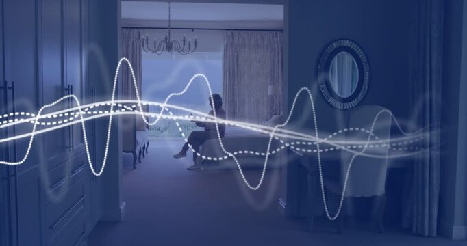Holding phone, senior woman in loungewear shifting in bedroom on bed, waveform drawing gaze