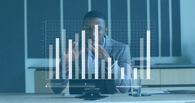 Vertical video: Gesturing man in grey suit reacting to chart updating, addressing camera at office