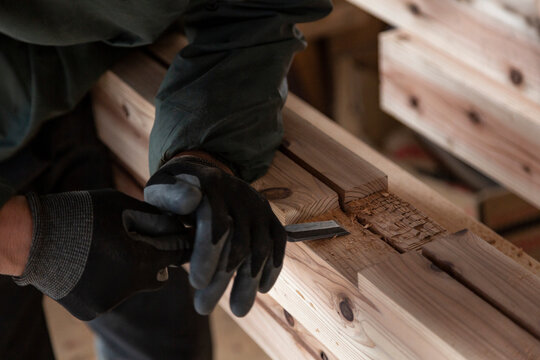 ノミを使って木材を加工する大工の職人技 伝統的な建築現場とリノベーションの施工風景