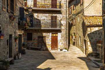 Obraz premium Abbadia San Salvatore old town street with sunlight and shadows, Tuscany, Italy.