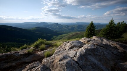 Fototapeta premium Expansive mountain panorama from a rocky summit with green valleys and a cloudy sky