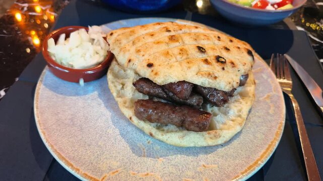 Sausage Cevapcici are traditional juicy Balkan sausages made from ground beef, grilled, and served with onions in pita bread. High quality 4k footage