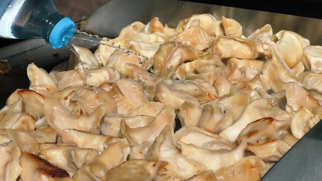 At a Chinese market, they prepare shui jiao, dumplings with a juicy filling of meat, seafood, or vegetables. The concept is Chinese cuisine. High quality 4k footage