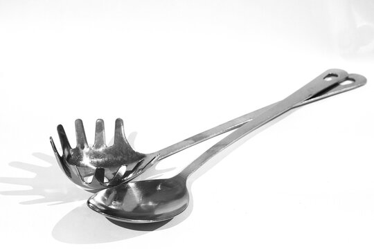 quality assortment of essential kitchen utensils including spatula, whisk, ladle, knives, neatly on a clean white surface, highlighting modern cooking tools and culinary preparation