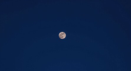 Fototapeta premium Full moon glowing brightly in an empty sky