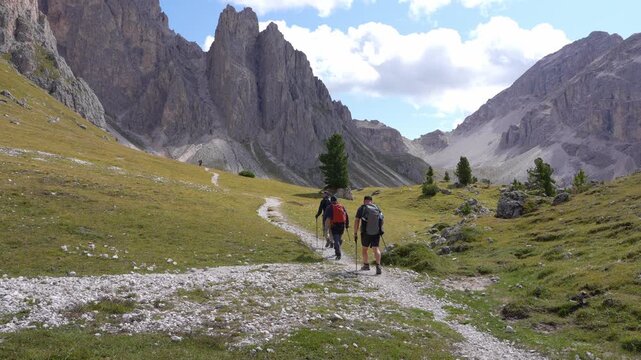 Hikers are going to the Geisler Peak Ridge in the Puez - Odle Nature Reserve. Dolomites.