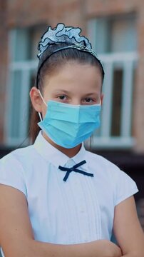 Teen schoolgirl wearing medical mask in empty schoolyard