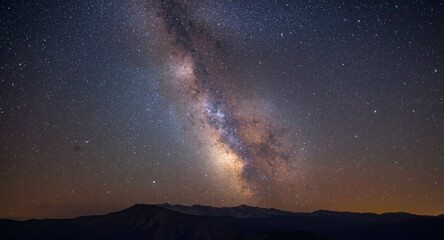 Fototapeta premium radiant milky way galaxy spanning star filled night sky above mountain range