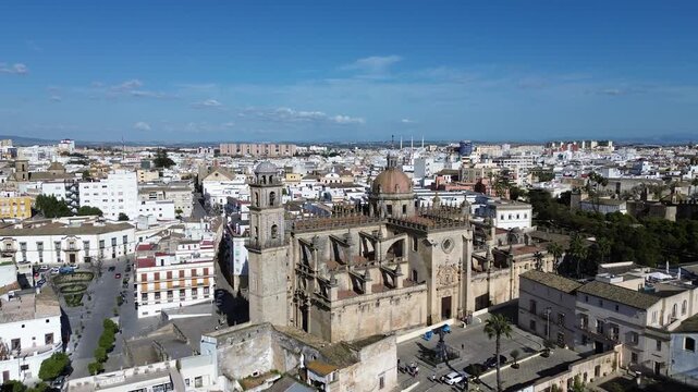 Aerial drone shot moving backwards in 4K resolution revealing a spectacular and wide panoramic view of the Jerez Cathedral and the entire historic city center under a clear sunny sky