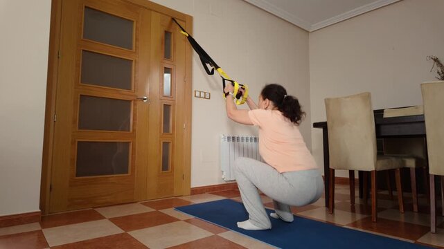 Active Woman Performing  Squats At Home For A Full Body Workout