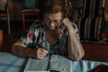 Obraz premium senior woman at home doing hobbies or a crossword puzzle