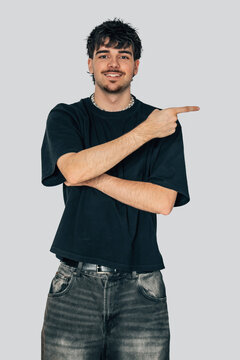 fashionable young man isolated on background pointing, vertical half-body portrait