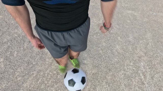 Point of view shot of a male athlete training his football skills. Young man performing a tricky dribble with the ball in slow motion