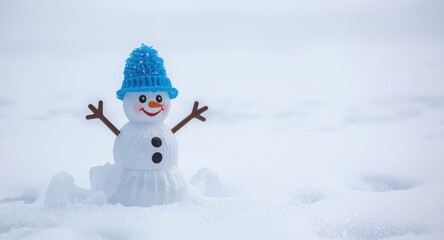 Fototapeta premium Playful toy snowman with a bright blue hat standing on smooth snowy ground with seasonal joy