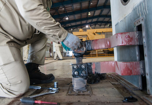 trabajador calificado desconectando barras electricas de excitador de un generador electrico de potencia en planta de energia electrica en MEXICO. quitando tornillos y tuercas entrenamiento y curso 