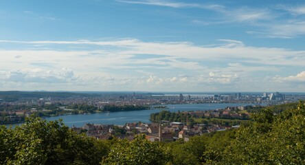 Obraz premium Scenic panorama of lake bordered by metropolitan district