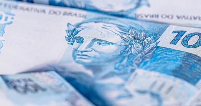 details of banknotes of 100 reais from brazil, and brazilian coins, with selective focus, background image. Promotion concept or grand prize money.