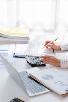 Business financing accounting banking concept. Business woman hand doing finances and calculate on desk about cost at home office. Woman working on desk with using calculator, finance accounting.