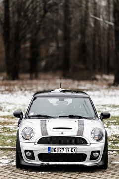 Silver Mini Cooper Parked On Snow-Dusted Parking Bay Near Forest On Overcast Winter Day