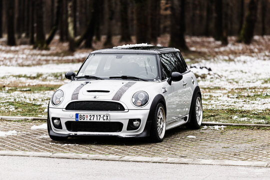 Silver Mini Cooper Parked On Snow-Dusted Parking Bay Near Forest On Overcast Winter Day