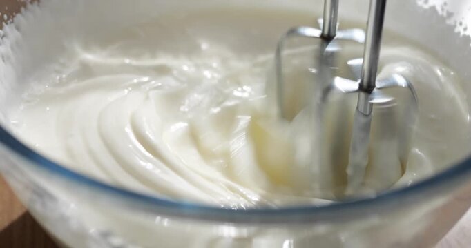 Beat the cream for the cake with a mixer. Confectionery mixture for greasing the cakes.