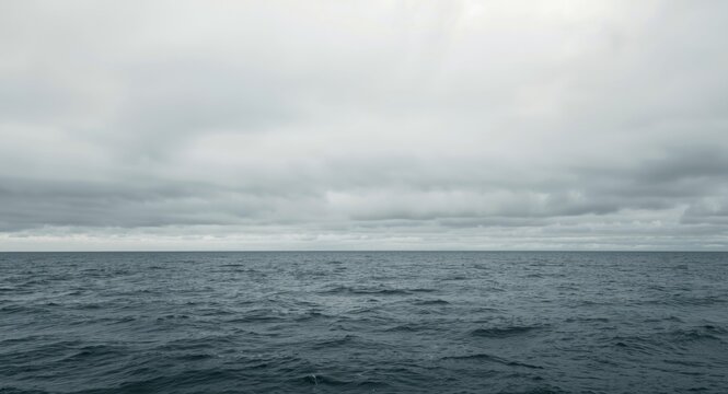 Ocean horizon with gray cloudy sky in a textured handmade paper collage copy space background