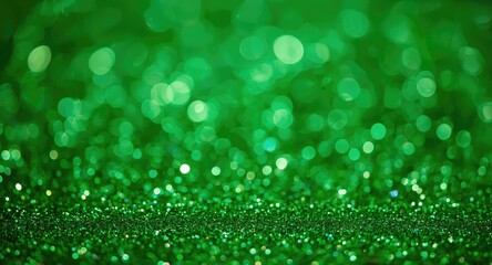 Fototapeta premium Festive shimmering glitter bokeh background with vibrant green hues ideal for holiday decorations