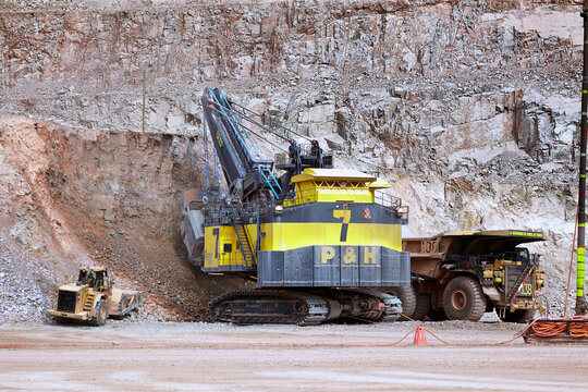 Large electric rope shovel loading an ultra-class haul truck in an open-pit mining operation, illustrating best practices in synchronized fleet management, operator awareness, and controlled loading c