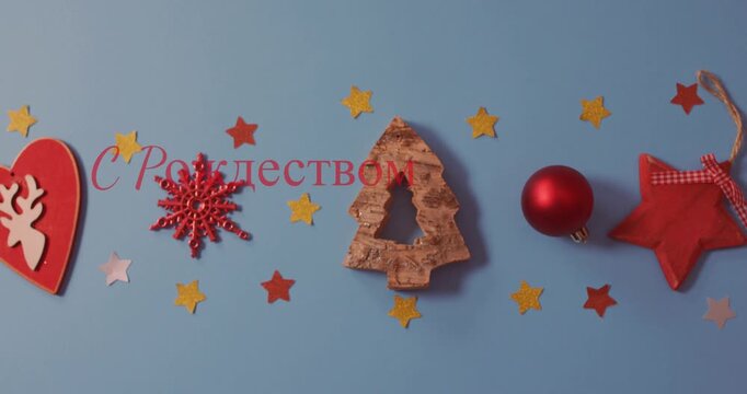 Animation of merry christmas in russian text over christmas decorations on blue background