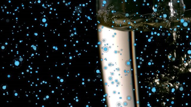 Animation of champagne pouring in flute and blue circles moving on black background