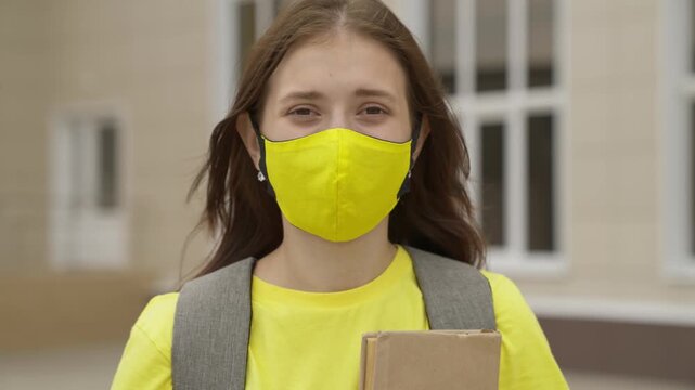 Young girl schoolgirl smiling in a protective mask, coronavirus pandemic, covid 19, safe walking around the city, helps from infections and dust, air filtration, keep healthy people safe, concept.