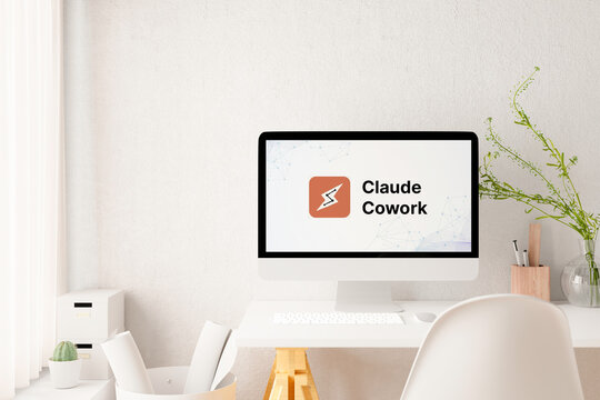 Computer monitor displaying claude cowork logo in modern office