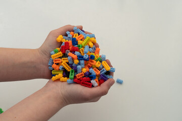 Multi-colored small LEGO construction pieces. © Juli