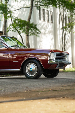 Dark red Chevrolet Opala front side profile and wheel, Classic vintage coupe on tree lined street