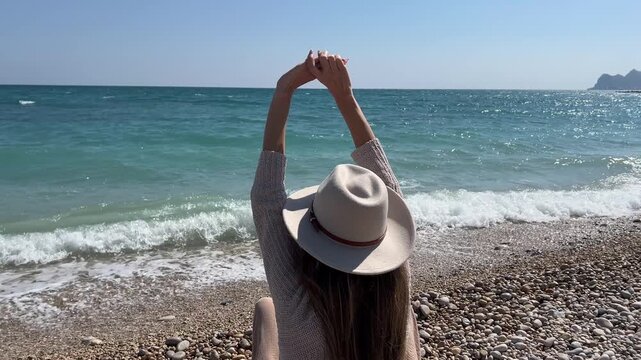 Plano trasero mujer mirando el horizonte estirando brazos