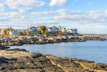 Modern oceanfront residential buildings on rocky cliffs at sunset in autumn