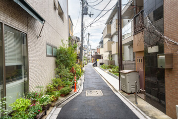 Deserted alley running between residential buildings on a cloudy autumn day. Kyoto, Japan.