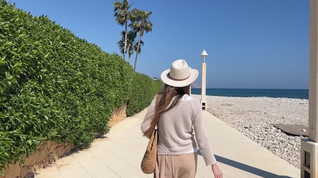 Seguimiento trasero a mujer caminando por el paseo mar&iacute;timo