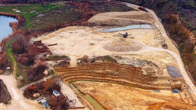 Flight over open-cast for sand mining. A truck stands in the center of the borrow pit.