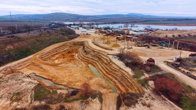 Heading to the large borrow pit for sand extraction. Equipment for mining and machinery in the backdrop.