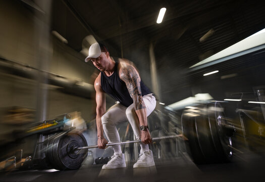 Fitness and health concept. A fit young man works out in a modern gym. Athletic man doing exercise.