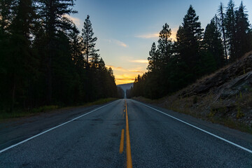Fototapeta premium lonely road in the mountains facing sunset