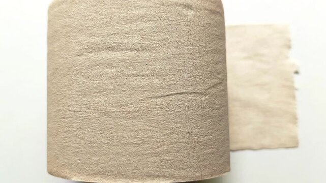 Brown recycled toilet paper roll with sheet isolated on white background and shadow