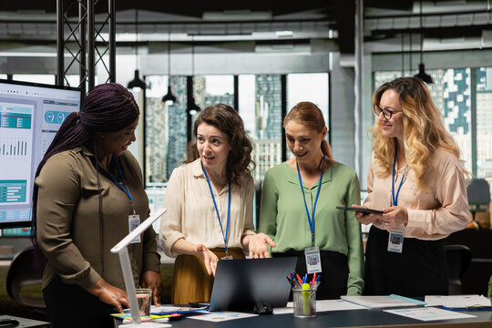 Career focused businesswomen reviewing analytics and aligning objectives, empowered by data and driven by vision. Strategizing performance improvements through teamwork and collaboration.