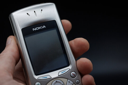 OURENSE, SPAIN - MARCH 25, 2026: Close-up of a classic Nokia mobile phone held in a hand against a dark background. Concept of early mobile technology, nostalgia, and evolution of communication device