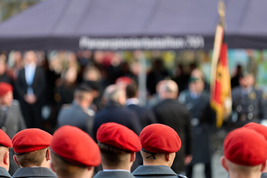 Military: Recruits in grey dress uniform coats and with red wool felt berets at a public oath ceremony