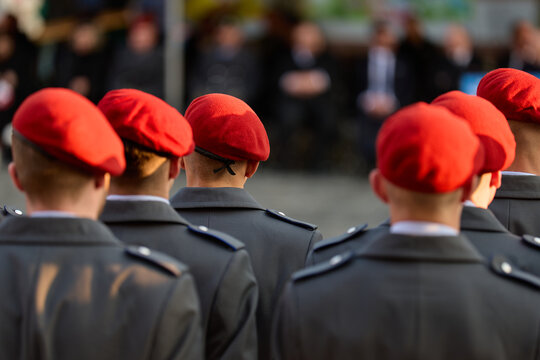 Military: Recruits in grey dress uniform coats and with red wool felt berets at a public oath ceremony