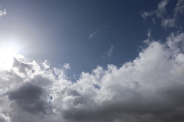 Fototapeta premium Beautiful blue sky with white fluffy cumulus clouds. Summer day background. High resolution nature texture suitable for wallpaper or design overlays