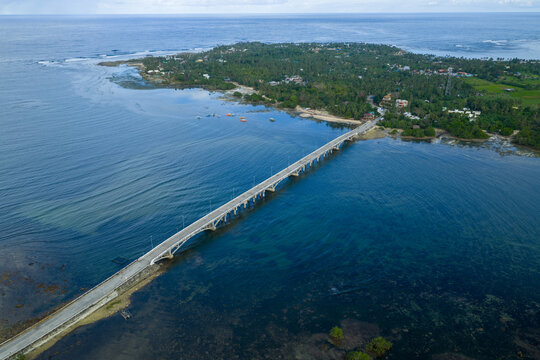 Aerial view of Afam Bridge in Siargao. Long concrete bridge crossing over turquoise water and mangrove forests, scenic coastal infrastructure in the Philippines.