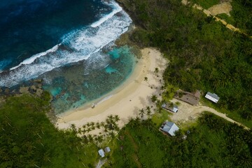Aerial view of Pasikon Beach, Siargao. Pristine white sand beach and turquoise lagoon surrounded by tropical palm trees and coral reefs, Philippines. © Matt